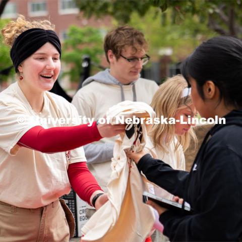 ASUN Student Government co-chair, Lily Rippeteau, hands out t-shirts to student volunteers before the start of the Big Event. May 4, 2024. Photo by Kirk Rangel for University Communication.
